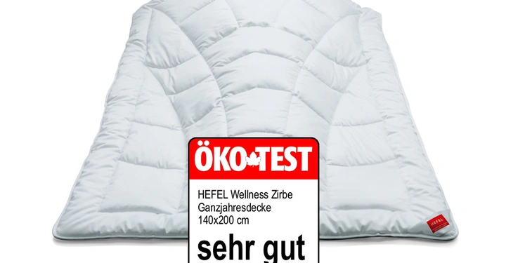 Weiße gesteppte Decke auf neutralem Hintergrund liegend ÖKO-TEST Zertifikat mit Text HEFEL Wellness Zirbe Ganzjahresdecke 140x200 cm sehr gut Ausgabe 09/2014