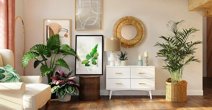 Ein cremefarbener Sessel mit grünen Kissen steht neben großen grünen Pflanzen auf einem Holzfußboden in einem stilvoll eingerichteten Wohnzimmer mit gerahmter Kunst, runden Spiegeln und einem weißen Schrank.