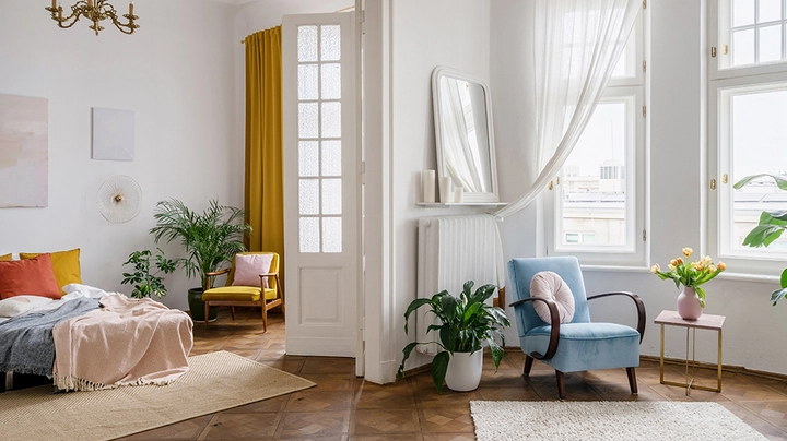 Eine moderne lichtdurchflutete Wohnung mit viel Weiß kombiniert mit bunten Vintagemöbeln.