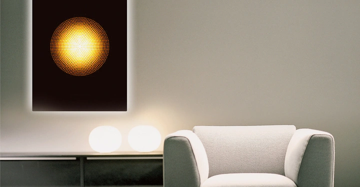Galerie-Bild 7: Ein weißer Sessel steht vor einer cremefarbenen Wand mit einem leuchtenden Kunstwerk darüber, das einen gelben Punkt in der Mitte darstellt. Rechts vom Sessel befinden sich zwei runde Leuchten.