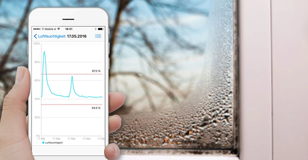Hand hält Smartphone zeigt Feuchtigkeitsdaten