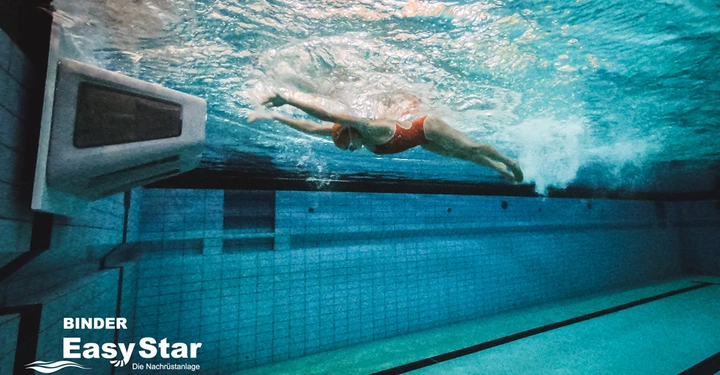 Galerie-Bild 2: Eine Person schwimmt unter Wasser in einem Schwimmbecken in Richtung eines Geräts an der Wand. Text im Bild BINDER EasyStar Die Nachrüstanlage.