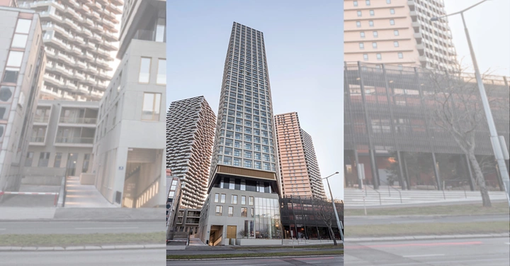 Hochhaus steht still zwischen zwei anderen Hochhäusern Umgebung aus weiteren Gebäuden und einer Straße im Vordergrund klare Himmel ohne Wolken