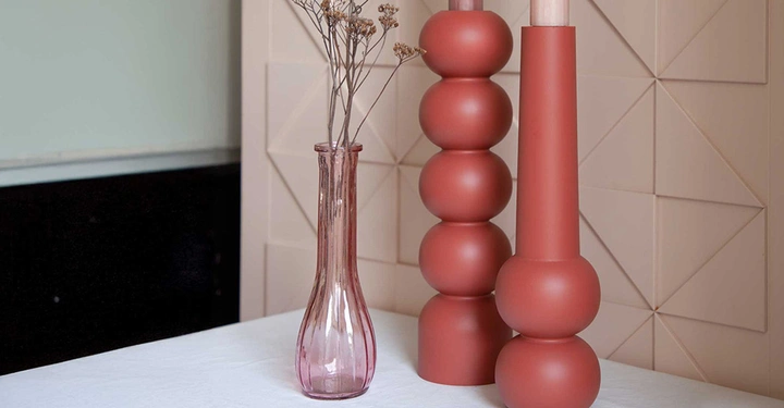 Moderne Kerzenhalter in Kugelform mit hohen Stabkerzen und minimalistischer Glasvase. Inspiration für Kerzen-Deko, Materialien und Kauftipps