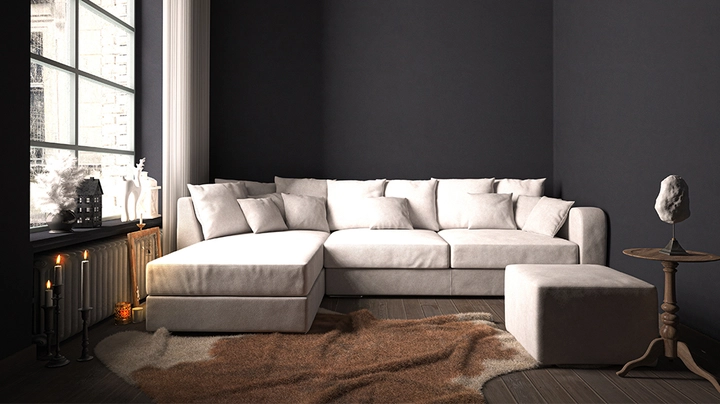helles großes Ecksofa vor dunkelblauer Wand, brauner Lederteppich auf Boden, Kerzenständer im Vordergrund