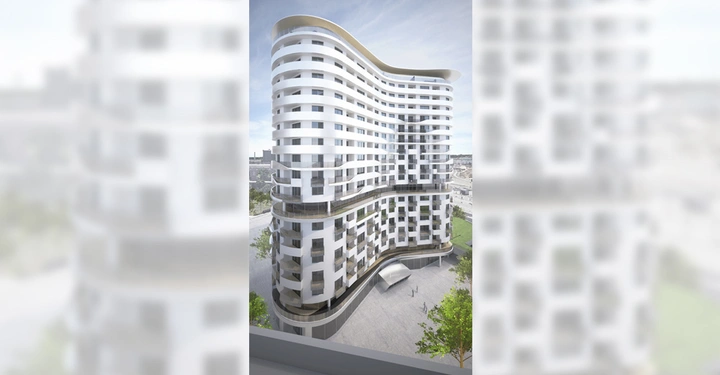 Hohes modernes Gebäude mit geschwungenen Linien und vielen Fenstern steht in einer städtischen Umgebung mit Betonplätzen und einigen Bäumen im Vordergrund.