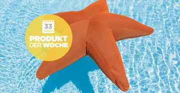 Ein orangefarbener Seestern-Schwimmreifen treibt auf klarem blauem Wasser in einem Pool. Ein gelber Kreis mit Text: 33 PRODUKT DER WOCHE überlappt das Bild.