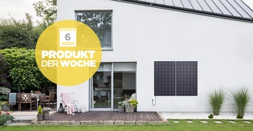 Ein modernes Haus mit Solarpaneelen an der Außenwand neben einer Terrasse mit Gartenmöbeln im grünen Garten. Text: 6 PRODUKT DER WOCHE