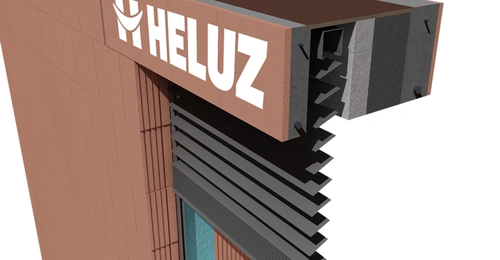 Mauerwerk mit der Aufschrift HELUZ montiert über einem Fenster mit ausgefahrener schwarzen Jalousie in einem Ziegelwand Kontext