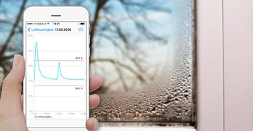 Hand hält Smartphone zeigt Feuchtigkeitsdaten
