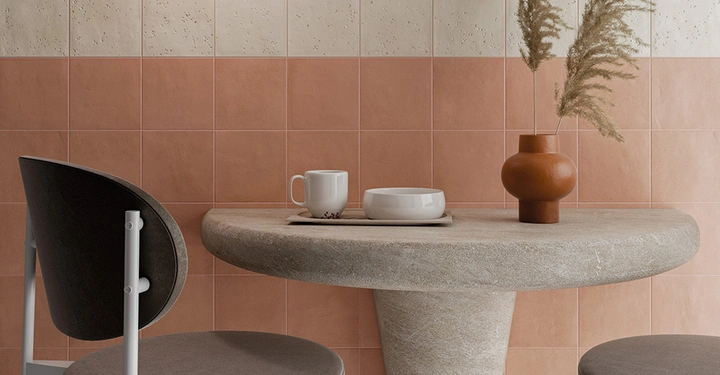 Galerie-Bild 4: Ein weißer Tisch vor einer Wand mit einer Fliesenwand in sanften Erdtönen mit einem weißen Streifen im subtilen Terrazzo-Design.