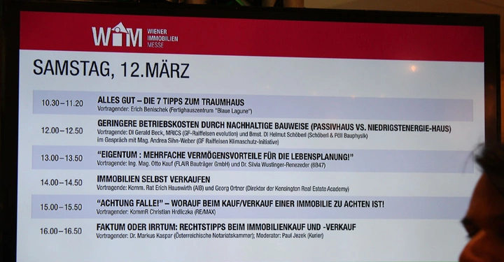 Galerie-Bild 2: Ein Bildschirm zeigt das Veranstaltungsprogramm für Samstag den 12. März auf der Wiener Immobilien Messe. Die Themen umfassen Traumhaus-Tipps nachhaltige Bauweise und rechtliche Aspekte des Immobilienkaufs und -verkaufs.
