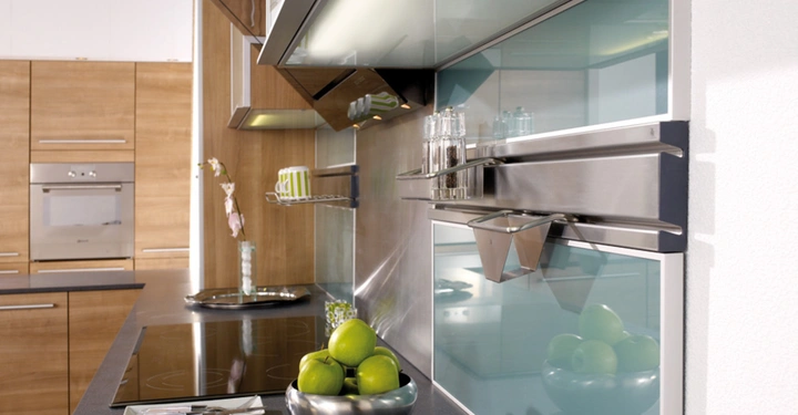 Galerie-Bild 8: Grüne Äpfel in einer Metallschale stehen auf einer Küchentheke; im Hintergrund moderne Küchenschränke und ein Glasregal mit Gewürzen und Tassen.