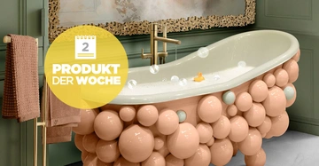 Badewanne mit Blasen an den Seiten steht in einem eleganten Badezimmer auf hellem Boden und vor einer grün gestrichenen Wand Nachricht 2 Produkt der Woche auf gelbem Kreis enthält Handtücher auf Ständer