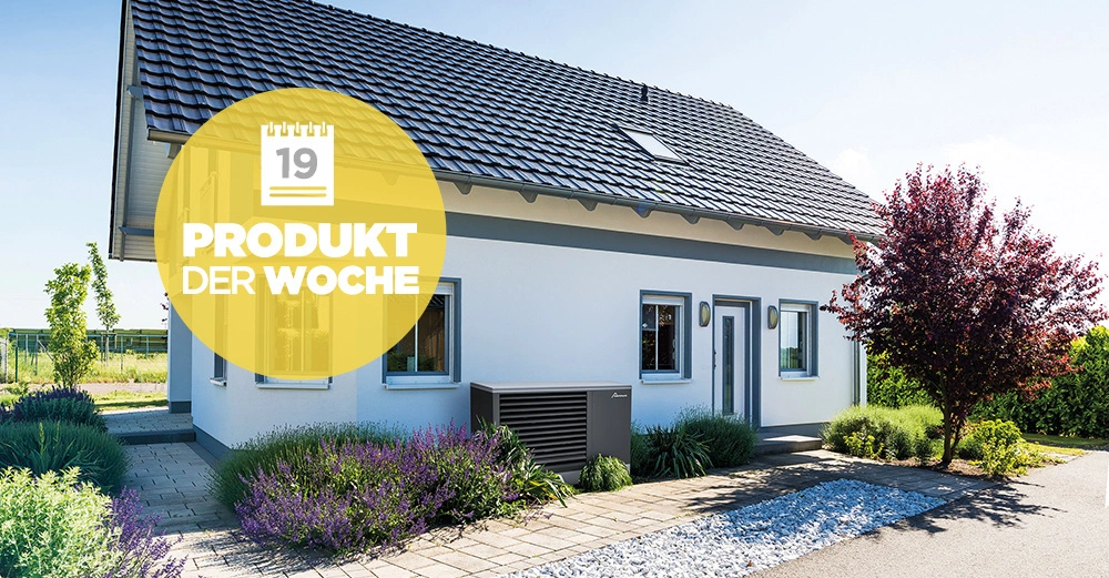 Ein weißes Einfamilienhaus mit dunkelgrauem Dach steht in einem gepflegten Garten, umgeben von Pflanzen und Sträuchern. Ein großer gelber Kreis zeigt den Text 19 Produkt der Woche.