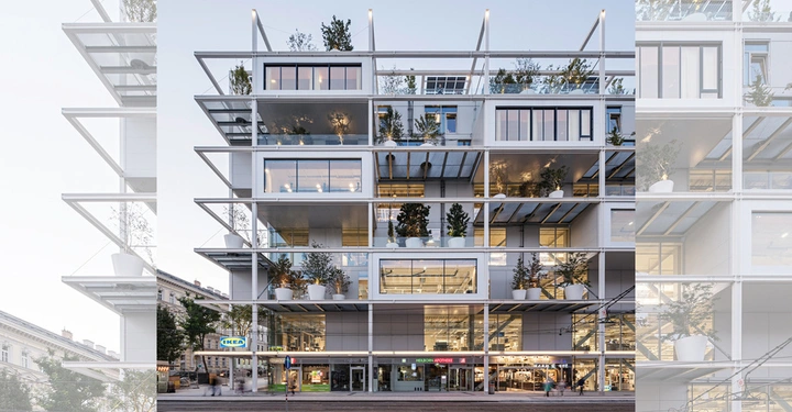 Modernes Gebäude zeigt viele große Fenster und Pflanzen auf verschiedenen Ebenen. Menschen gehen entlang des Gehwegs daneben. Im Erdgeschoss befinden sich Geschäfte wie IKEA und Helden Apotheke.