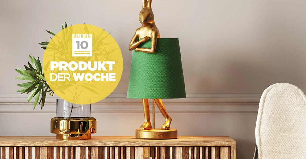 Stehlampe Animal Rabbit in Gold mit tiefgrünem Lampenschirm steht auf hölzernem Sideboard. Daneben eine kleine Topfpflanze in goldenem Übertopf.