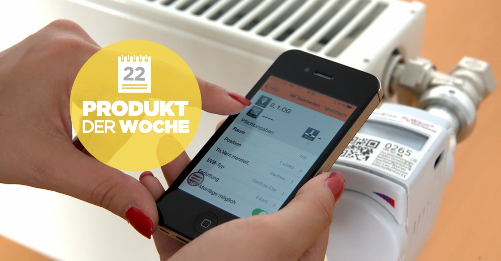 Eine Hand hält ein Smartphone zeigt eine App Bedienoberfläche ist in der Nähe eines Heizkörpers montiertem Geräts Text 22 PRODUKT DER WOCHE im gelben Kreis