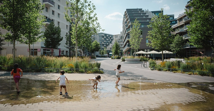 Die Seestadt Aspern, eine Stadt in der Stadt Wien, bietet Parks, Spielplätze, Grünflächen und den namengebenden See. 2022 wurde unter anderem der Simone-de-Beauvoir-Platz (im Bild) intensiv nachbegrünt.