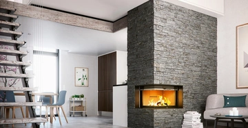 Kamin brennt in einem modernen Wohnzimmer Holzboden links Treppe rechts Sofa und Tisch mit Büchern dahinter Küche mit braunen Schränken daneben runder Esstisch mit blauen Stühlen helle Wand mit Kunstwerk