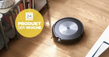 Ein Saugroboter reinigt einen Wohnzimmerboden neben einem Regal mit Büchern und Dekorationen. Text auf gelbem Kreis: 24 PRODUKT DER WOCHE.