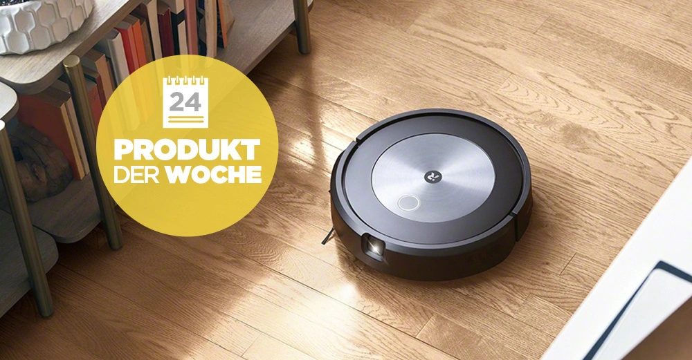 Ein Saugroboter reinigt einen Wohnzimmerboden neben einem Regal mit Büchern und Dekorationen. Text auf gelbem Kreis: 24 PRODUKT DER WOCHE.