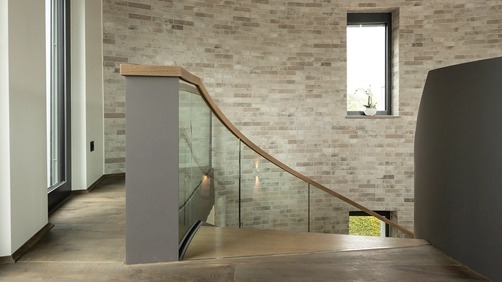 Galerie-Bild 4: Treppe in einem Dachgeschoß, die nach unten führt, Wände aus Steinziegeln in hellem Beige.