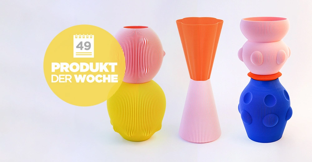 Drei bunte dekorative Vasen stehen nebeneinander auf einem hellen Hintergrund Eine Vase ist gelb-rot Eine ist orange-rosa Eine ist blau-rosa Links oben befindet sich ein gelber Kreis mit der Aufschrift 49 PRODUKT DER WOCHE