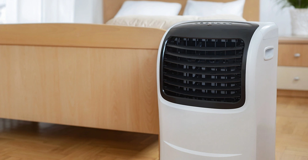 Mobiles Klimagerät im Schlafzimmer zuhause, tragbare Klimaanlage sorgt für angenehme Raumtemperatur, energiesparend und flexibel einsetzbar
