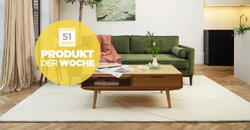 Coffeetable von Swyft in Eiche gebürstet steht in Wohnzimmer, im Hintergrund eine olivgrüne Couch mit Zierkissen und Plaid, angenehmes Ambiente 