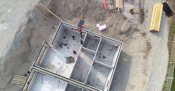 Luftaufnahme eines neu errichteten Betonkellers in der Baugrube