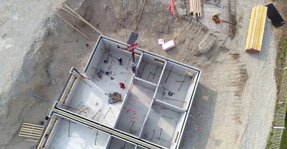 Luftaufnahme eines neu errichteten Betonkellers in der Baugrube