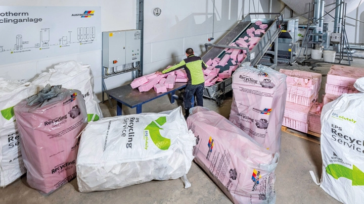 Austrotherm Recyclinganlage mit einem Mitarbeiter, der Dämmstoffabfälle sortiert.