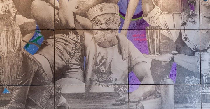 Graffiti-Abbildung eines grimmig dreinschauenden bärtigen Mannes im Matrosenhut und Shirt mit einem Segelschiffmuster, umgeben von Menschen im Hintergrund. Text: SHUT UP AND DANCE.