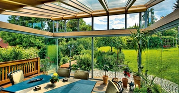 Ein gemütlich eingerichteter Wintergarten mit Blick ins Grüne