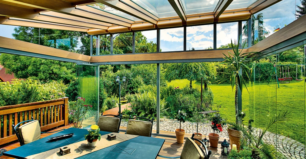 Ein gemütlich eingerichteter Wintergarten mit Blick ins Grüne