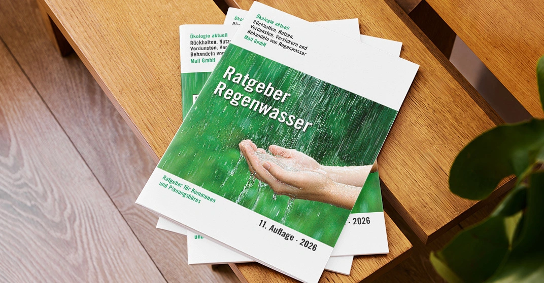 Mehrere Broschüren mit Titel Ratgeber Regenwasser liegen auf moderner Holzbank.