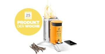 Herd lädt ein Smartphone auf vermittelt durch Kabel im Freien Text im Bild Produkt Der Woche BioLite 25 umgeben von einem Stapel Zweigen