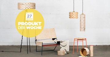 Ein Holzstuhl und verschiedene Holzmöbel werden in einem kargen Raum präsentiert. Links erscheint ein gelber Kreis mit der Aufschrift 27 PRODUKT DER WOCHE.