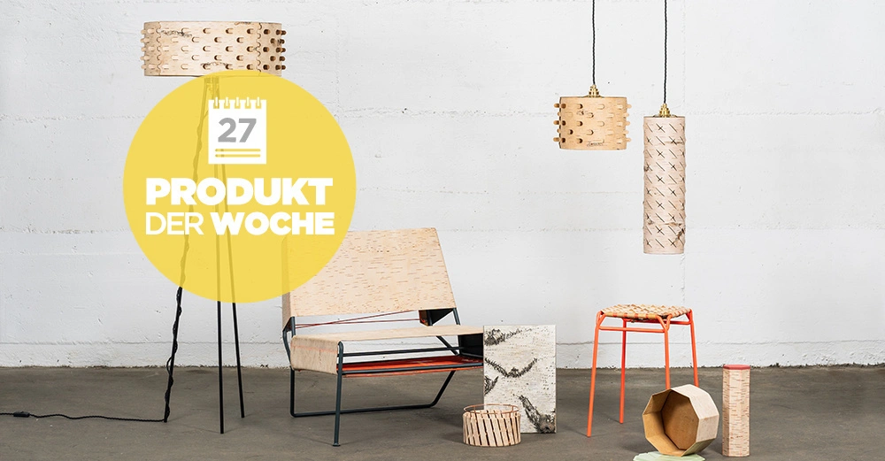 Ein Holzstuhl und verschiedene Holzmöbel werden in einem kargen Raum präsentiert. Links erscheint ein gelber Kreis mit der Aufschrift 27 PRODUKT DER WOCHE.