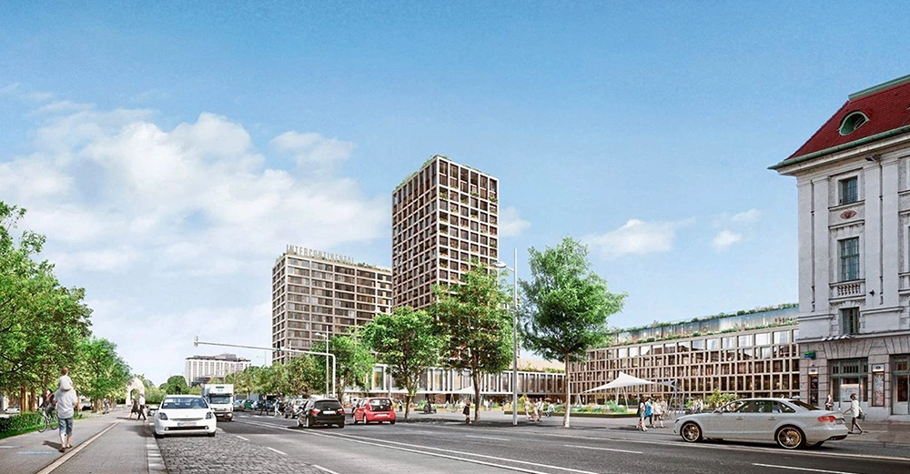 Mehrere Autos fahren auf einer breiten Straße. Hochhäuser und moderne Gebäude prägen die Umgebung. Menschen gehen am Bürgersteig entlang. Der Himmel ist leicht bewölkt. Text: Metropol Park.