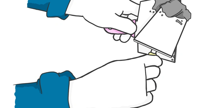 Hände halten eine Spachtel und ein Spachtelwerkzeug verstreichen graue Paste auf dem Werkzeug Hintergrund weiß beide Hände tragen blaue Ärmel.