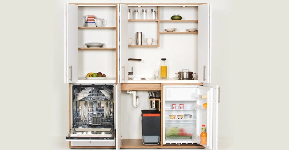 Küchenzeile - Spülmaschine und Kühlschrank geöffnet - In einem modernen, kompakten Küchenschrank. Oben stehen Geschirrregale, mittig eine Arbeitsfläche mit Spüle, auf der rechten Seite ein kleiner Herdplatte.