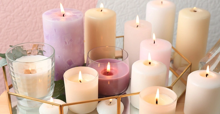 Auswahl an brennenden Kerzen. Unterschiedliche Farben, Hersteller und Größen zeigen die Vielfalt von Kerzen.