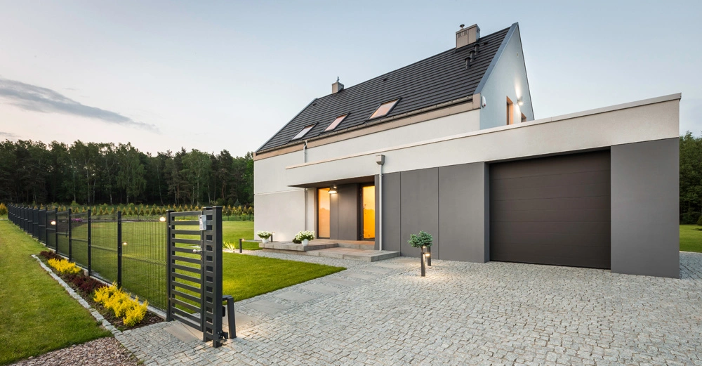 Einfamilienhaus mit Steildach, gepflasterter Vorplatz, kleiner Garten, Zaun. cleanes, modernes Setting