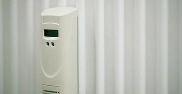 älterer Heizkostenzähle in weißem Kunststoff auf weißem Heizkörper in Großansicht