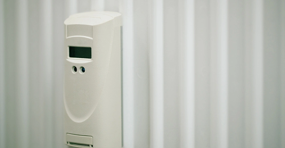 älterer Heizkostenzähle in weißem Kunststoff auf weißem Heizkörper in Großansicht