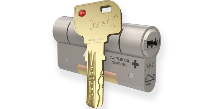 Ein goldener Schlüssel mit der Aufschrift M&C und GESCHÜTZT steckt in einem silbernen Zylinderschloss im Hintergrund steht SWITZERLAND SECURITY TECH und ein Symbol mit einem Kreuz