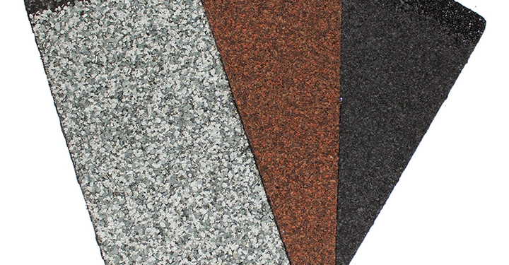 Drei rechteckige Dachschindeln in Grau Braun und Schwarz nebeneinander liegend auf weißem Hintergrund. Die Oberflächen sind körnig und rau.