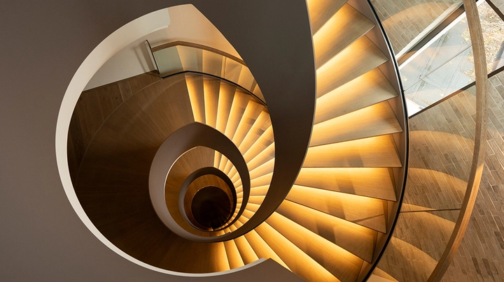 Galerie-Bild 1: Aufnahme von oben, imposante Wendesltreppe in warmer LED-Beleuchtung